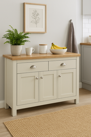 Cream sideboard cabinet with oak top, featuring three doors and two drawers, used as a stylish storage unit for living or dining room.