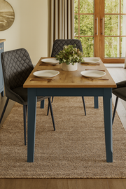 Blue Baumhaus Signature dining table with sleek wooden surface, set up with chairs in a modern dining room.