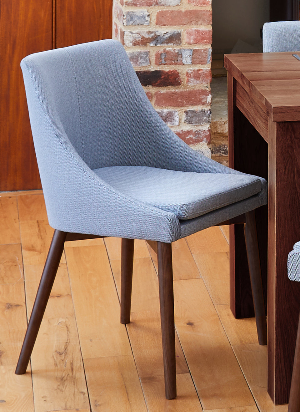 Pair of Baumhaus Walnut Light Grey and Grey dining chairs with wooden legs, shown in a modern home setting.