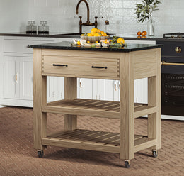 Baumhaus oak kitchen island with two drawers, black granite top, and brake wheels, showcasing a functional design.