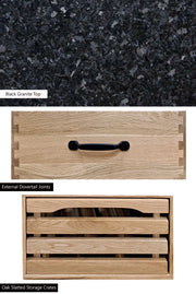 Oak kitchen island by Baumhaus with two drawers, black granite top, and brake wheels, showcasing modern design and functionality.