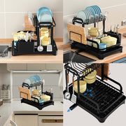 Black 2-tier dish drainer rack with drainage spout, utensil and cutting board holders, for kitchen counter drying.