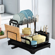 Black 2-tier dish drainer rack with drainage spout, utensil and cutting board holders, ideal for kitchen counter drying.