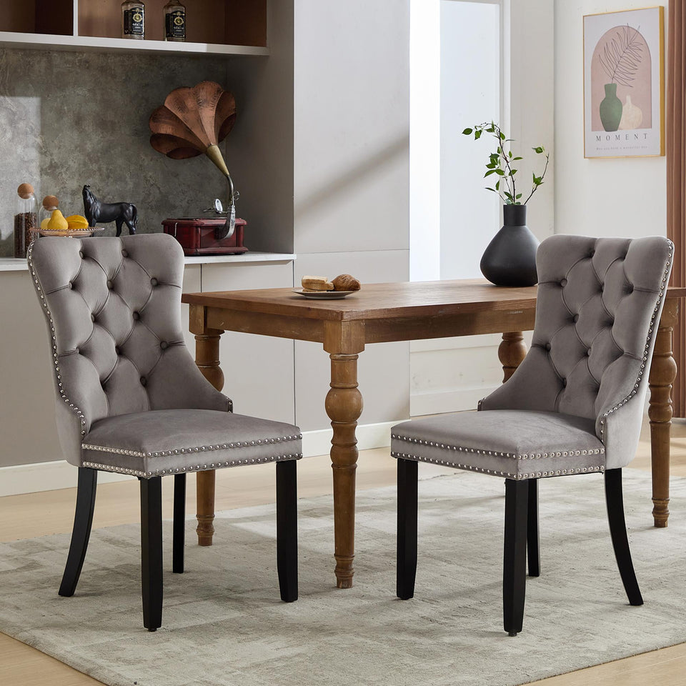 Set of 2 Lavish Kitchen Isle velvet dining chairs with button tufted backrests, one grey and one beige, with knocker ring accents.