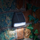 Set of four superbright LED solar-powered fence and wall lights in black and white by Lavish Kitchen Isle.