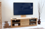 Baumhaus Mobel Oak mounted widescreen television cabinet with spacious shelves and a sleek design in a modern living room setting.